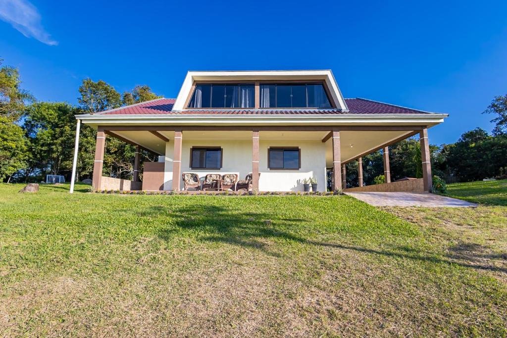 Fachada da casa com varanda e jardim