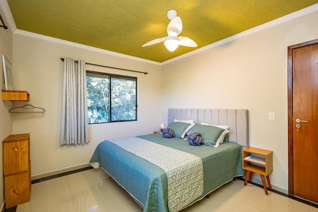 Quarto com cama de casal e teto verde
