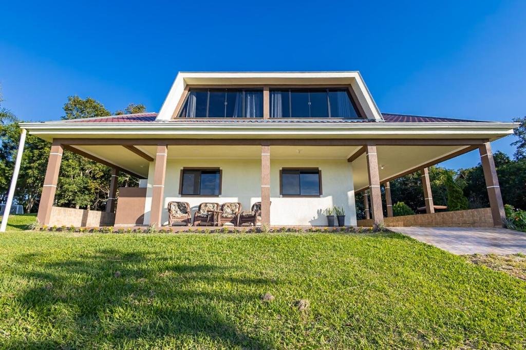 Fachada da casa com varanda e cadeiras