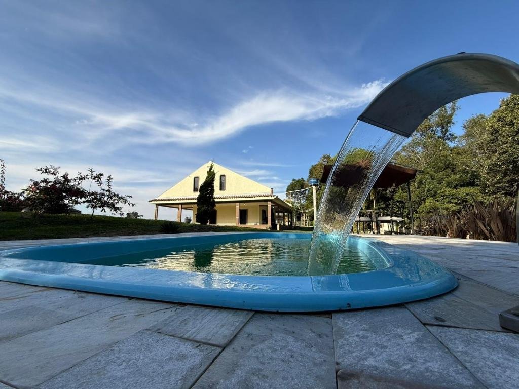 Piscina com fonte e casa ao fundo